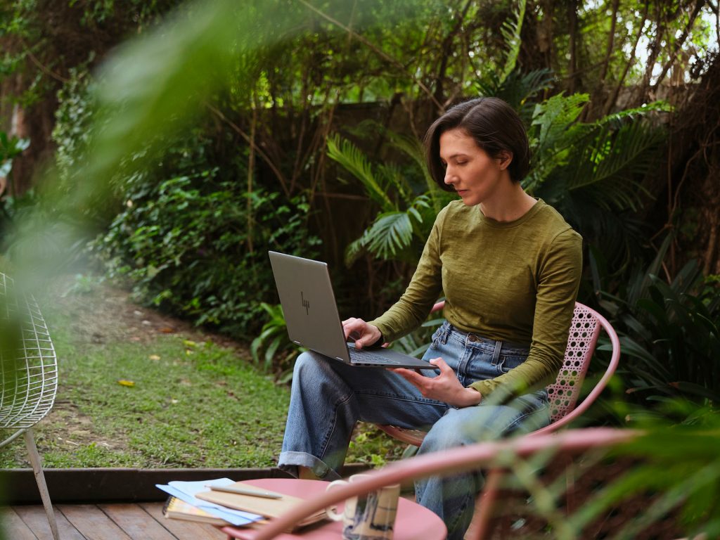 Person working on laptop outdoors.