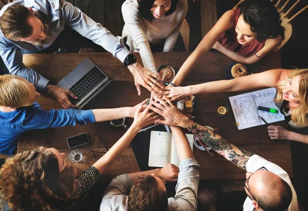 Hands joining together over a table.
